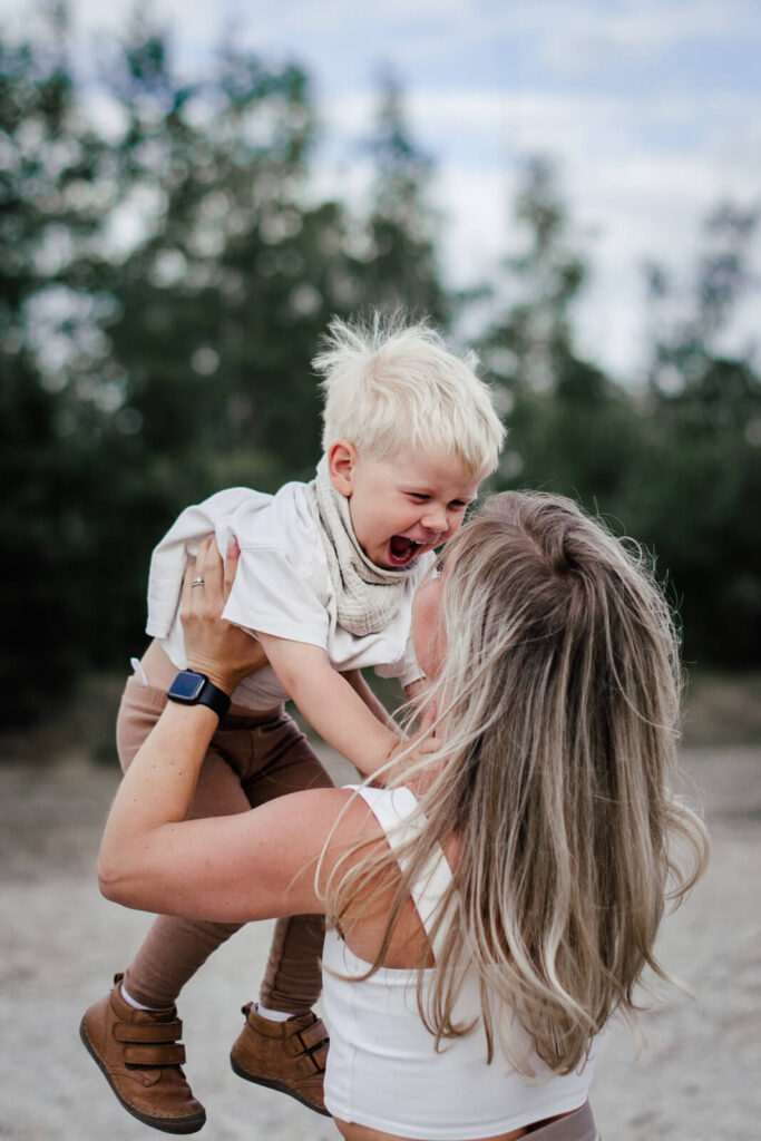 Familienfotograf Leipzig. Mutter und Kind spielen am Seeufer.
